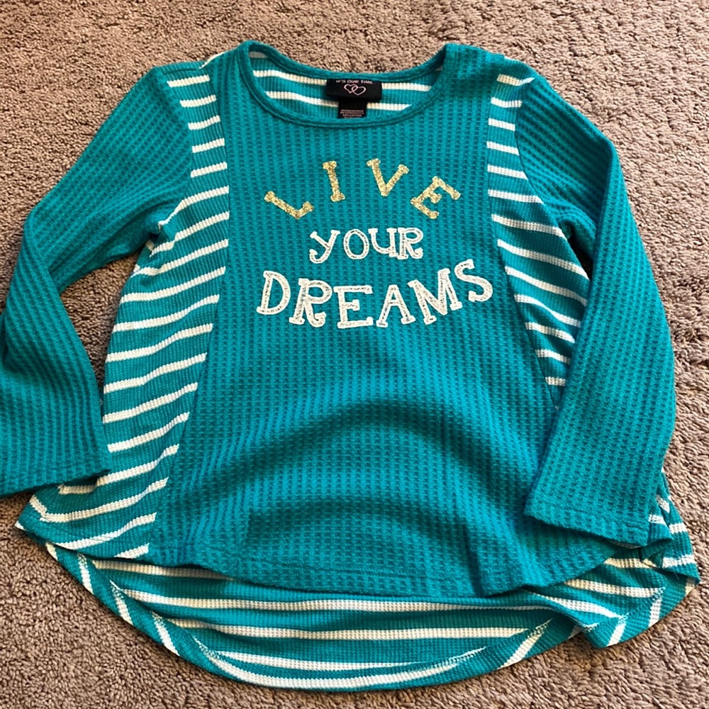 More of a teal color shirt that says “Live your dreams”